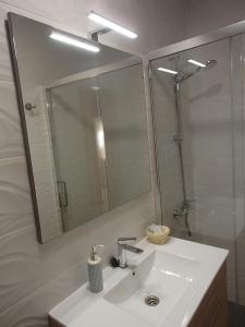 een badkamer met een wastafel en een grote spiegel bij Apartamento El Aljibe de la Luz in Toledo