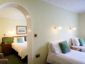 
a hotel room with two beds and a mirror at The Izaak Walton Country House Hotel in Ashbourne
