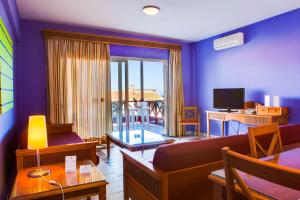 a living room with a couch and a room with a balcony at Aparthotel El Cerrito in Los Cancajos