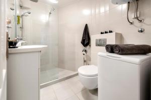 a white bathroom with a toilet and a shower at Nel Centro City Apartment in Rovinj