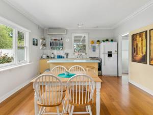 a kitchen with a table and chairs and a refrigerator at Strathallan in Cowes +12 photos