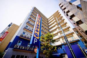 un edificio azul con una señal de estacionamiento delante de él en Super Hotel Saitama Omiya West, en Saitama