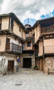 un edificio con balcones en un lateral en La Serrana de la Vera Casa Rural, en Garganta la Olla