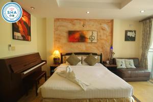 a bedroom with a piano and a bed with shoes on it at My Way Hua Hin Music Hotel SHA Extra Plus in Hua Hin