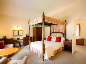 
a bedroom with a large bed and a large window at The Izaak Walton Country House Hotel in Ashbourne
