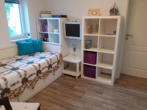 a bedroom with a bed and a tv and shelves at Ferienhaus Ciara in Splietsdorf