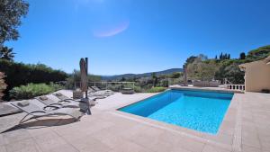 a swimming pool with lounge chairs next to a house at Villa Alinea in Sainte-Maxime