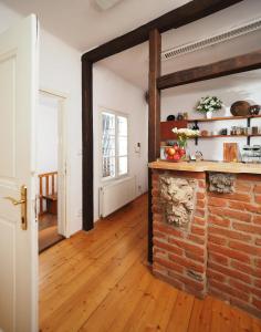 a living room with a brick fireplace and wooden floors at Penzion Kamenne Slunce in Telč