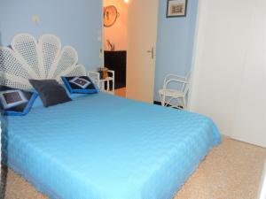 ein Schlafzimmer mit einem blauen Bett mit blauer Decke in der Unterkunft T2 vue mer quartier calme Grau du roi in Le Grau-du-Roi