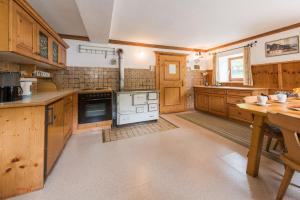 a large kitchen with wooden cabinets and a stove at Almliesl GAST-387 in Bad Gastein