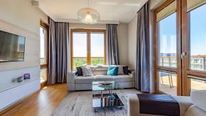 a living room with a couch and a tv at VacationClub - Olympic Park Apartment A604 in Kołobrzeg