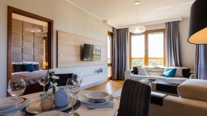 a living room with a table and a couch at VacationClub - Olympic Park Apartment A604 in Kołobrzeg