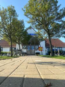 a building with trees in front of a street at Zeepark Zeewind in Bredene