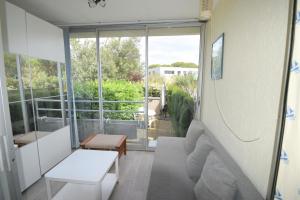 ein Wohnzimmer mit einem Sofa und einem Tisch in der Unterkunft les jardins du port studio avec jardin et piscine in Le Grau-du-Roi
