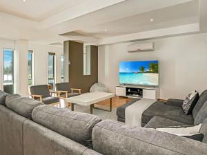 a living room with a couch and a flat screen tv at Saltwater Haven in Cowes