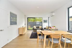 a dining room and living room with a table and chairs at Salisbury Style - Brand new city apartment - Christchurch Holiday Homes in Christchurch
