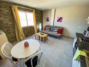 eine Küche und ein Wohnzimmer mit einem Tisch und einem Sofa in der Unterkunft Edificio Prieto VIV 6 in Puerto del Rosario