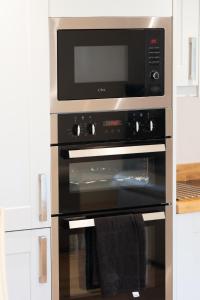La cocina está equipada con horno y microondas. en Garden Villa en Cambridge