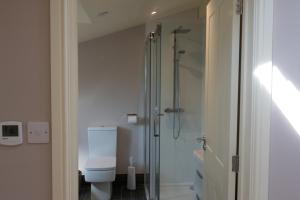 a bathroom with a toilet and a glass shower at Garden Villa in Cambridge