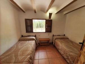 two beds in a room with a window at CABAÑAS RIO MUNDO in Riópar