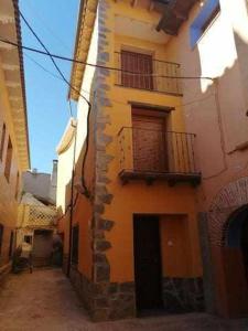 eine Gasse mit einem Gebäude mit einem Balkon in der Unterkunft Casa Rural La Malena in Azuara