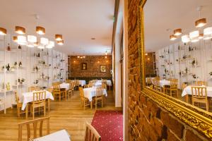 a dining room with white tables and a mirror at Casa Del Sole in Alba Iulia