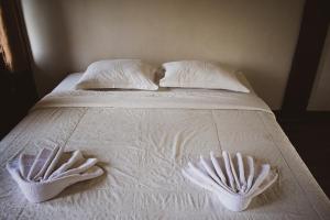 Taman Dolan Home & Resort في باتو: سرير ابيض عليه منشفتين بيضاء