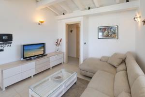 カステルサルドにあるResidence Auroraのソファとテレビのあるリビングルーム