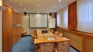 a conference room with a table and a projection screen at Hotel Ilbertz in Cologne