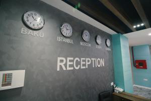 a wall with clocks on it with the words baku and reception at Tour-ZamZam-Madinah Halal Hotels Group in Baku