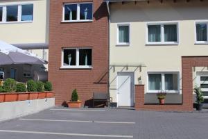 - un bâtiment en briques avec une chaise devant dans l'établissement Landhaus Jägerkrug, à Paderborn