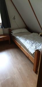 Cama pequeña en habitación con suelo de madera en Ferienhaus Nr. 60 Im Ferienpark am Twistesee, en Bad Arolsen