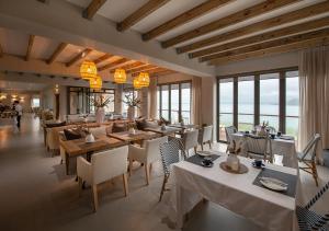 a restaurant with tables and chairs and windows at Shark Bay Hotel & Spa in Langebaan