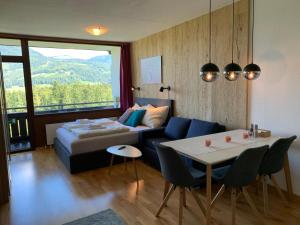 a bedroom with a bed and a table and a couch at Alpenblick Suite in Bad Goisern