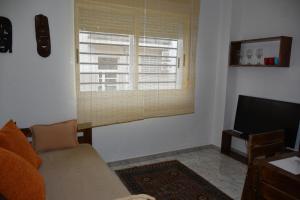 sala de estar con sofá y ventana en Apartamento Barbancho, en Casar de Cáceres