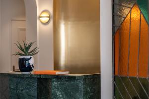 a green vase sitting on top of a counter next to a wall at Hotel Le Friedland in Paris