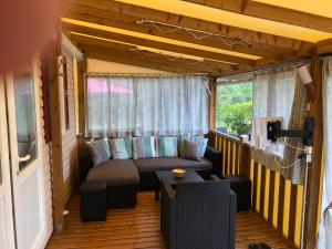 una veranda schermata con divano e tavolo di Mobile-home aux Cigales,Le Muy Colorado 4-6 Personnes a Le Muy
