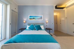een slaapkamer met een groot bed met blauwe kussens bij B&B La Piazzetta in Ischia