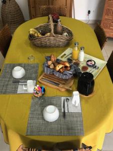 einen gelben Tisch mit einem Korb mit Essen drauf. in der Unterkunft BELLILOIRE, Chambre à la campagne in Belligné