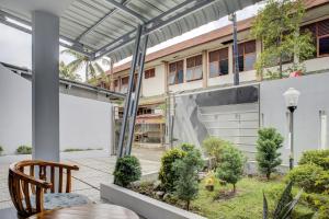 an outdoor patio with a wooden chair and a building at OYO 3690 Wisma Yani Syariah in Padang