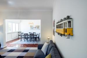 a living room with a couch and a train on the wall at Casa do Largo Electrico - Cozy and lovely apartment in the city center in Lisbon
