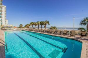 a large swimming pool with chairs and the beach at A Piece of Paradise, Newly Renovated in Myrtle Beach