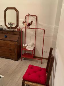 Habitación con reposapiés rojo frente a un espejo en Apartment De' Ramaglianti, en Florencia
