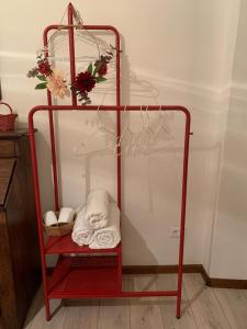 a red towel rack with towels and flowers on it at Apartment De' Ramaglianti in Florence