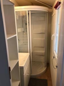 a white bathroom with a shower and a sink at Mobile-home aux Cigales,Le Muy Colorado 4-6 Personnes in Le Muy