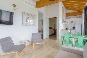 a living room with a table and chairs and a kitchen at Apartamentos Rurales Las Garzas de Oyambre in San Vicente de la Barquera