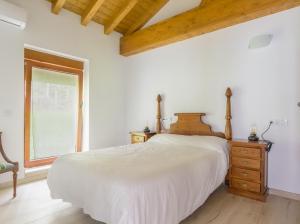 una camera da letto con un grande letto bianco e una finestra di Apartamentos Rurales Las Garzas de Oyambre a San Vicente de la Barquera