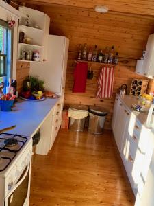 - une cuisine avec des appareils blancs et des murs en bois dans l'établissement Majorsgrund - Private Island, à Malax
