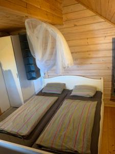 - 2 lits dans une petite chambre avec des murs en bois dans l'établissement Majorsgrund - Private Island, à Malax