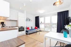 a kitchen and living room with a couch and a table at Marine Apartment 9B by Renters in Dziwnówek